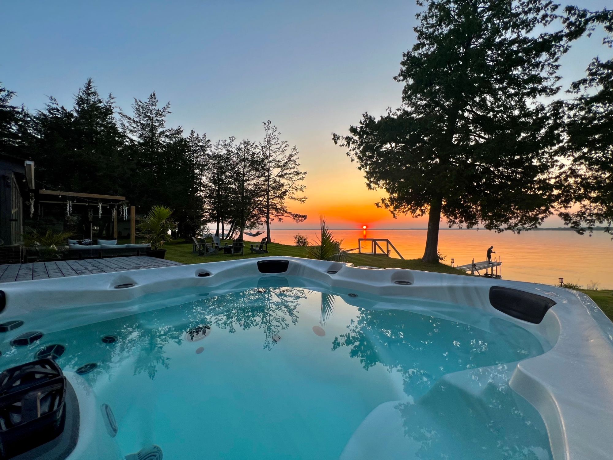 Saltwater hot tub overlooking the lawn, dock and sunset over the bay
